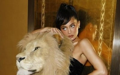 Youngest billionaire has a giant stuffed lion head on his shoulder