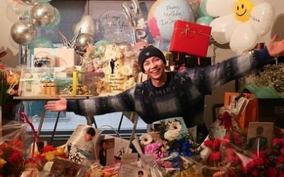Lee Seung-gi with shaved head, smiling while wearing a beanie