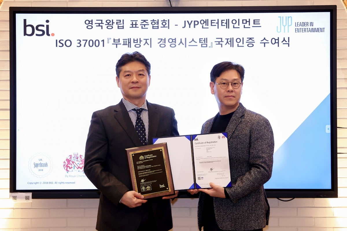 사진 설명: JYP엔터테인먼트 정욱 대표이사(오른쪽)과 BSI Korea 임성환 대표가 JYP 본사에서 개최된 부패방지 경영시스템(ISO 37001) 국제 인증 수여식을 마치고 기념 촬영을 하고 있다.