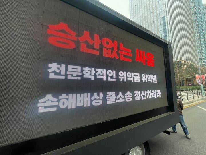 "천문학적 위약금, 뉴진스 정신 차려"…팬덤, '뼈 때리는' 트럭 시위 [TEN이슈]